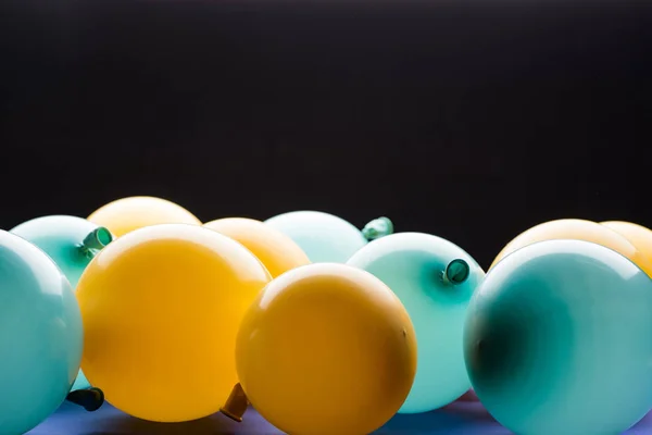 Enfoque selectivo de globos amarillos y azules aislados en negro - foto de stock