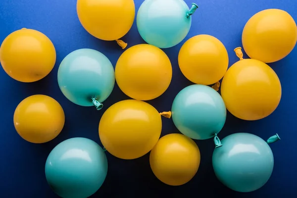 Vue de dessus des ballons jaunes et bleus fond festif — Photo de stock