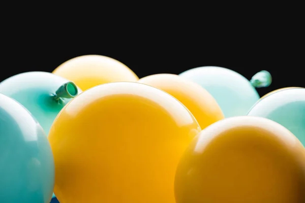 Vue rapprochée des ballons jaunes et bleus isolés sur noir — Photo de stock