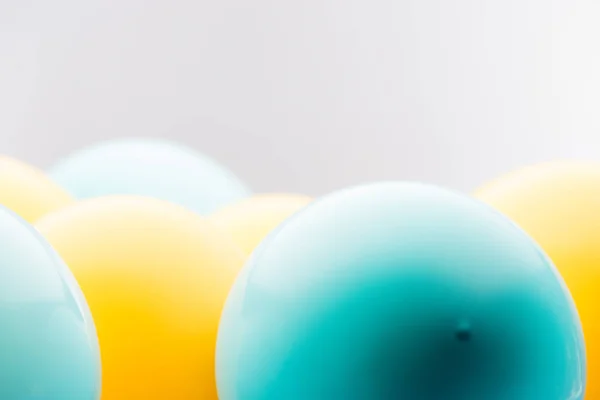 Vue rapprochée des ballons bleus et jaunes isolés sur gris — Photo de stock