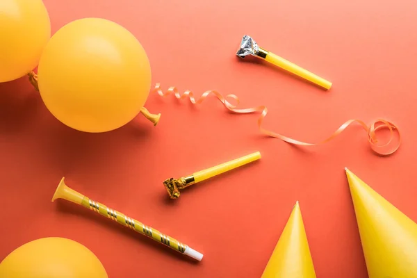 Vue du dessus de la décoration de fête jaune sur fond de fête corail — Photo de stock