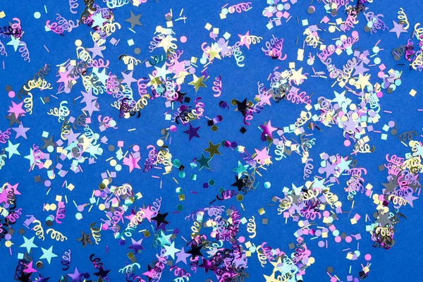 Vista dall'alto di coriandoli scintillanti colorati su sfondo blu — Foto stock