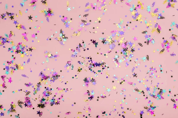 Vue du dessus des confettis colorés sur fond de fête rose — Photo de stock