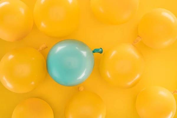 Yellow balloons and blue one on yellow background — Stock Photo