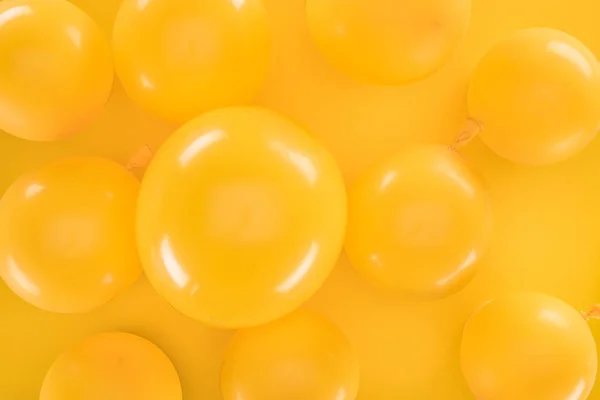 Vista superior globos amarillos sobre fondo amarillo - foto de stock