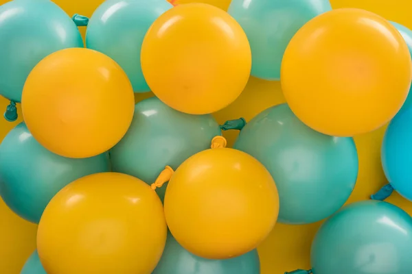 Желтые и голубые воздушные шары, праздничное оформление на желтом фоне — стоковое фото