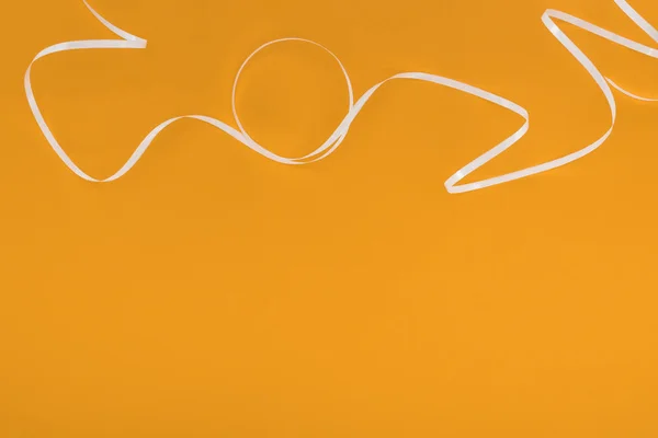 Top view of white ribbon on orange background — Stock Photo