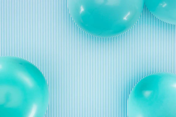 Vue du dessus des ballons bleus sur fond rayé bleu et blanc — Photo de stock