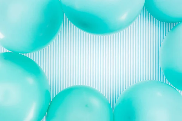 Вид зверху на рамку блакитних кульок на смугастому фоні — стокове фото