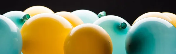 Vue panoramique de ballons jaunes et bleus isolés sur noir — Photo de stock