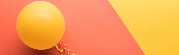 Panoramic shot of yellow balloon on coral minimalistic background — Stock Photo