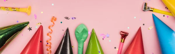 Panoramic shot of party decoration and party hats on pink background — Stock Photo