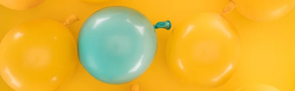 Panoramic shot of yellow and blue balloons on bright background — Stock Photo