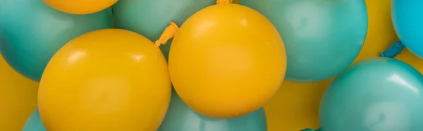 Panoramic shot of yellow and blue balloons party decoration on yellow background — Stock Photo