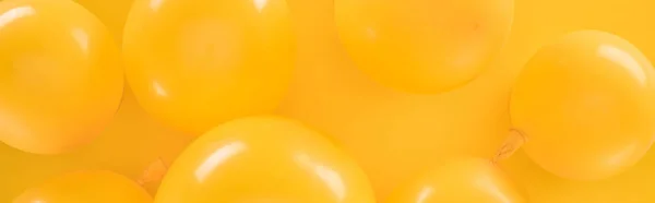 Foto panorámica de globos amarillos sobre fondo amarillo - foto de stock