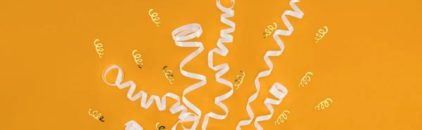 Panoramic shot of white ribbons on orange background, surprise party concept — Stock Photo