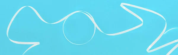 Panoramic shot of white ribbon on blue festive background — Stock Photo