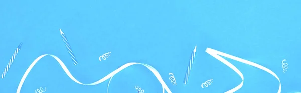 Colpo panoramico di nastro bianco e candele su sfondo blu — Foto stock