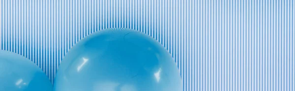 Panoramic shot of blue balloons on blue and white striped background — Stock Photo