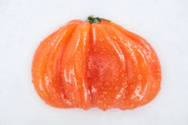 Vista superior de tomate húmedo rojo entero con gotas de agua aisladas en blanco - foto de stock