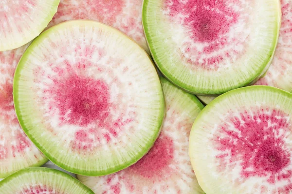 Close up view of cut raw purple fresh armelon radish slices — стоковое фото