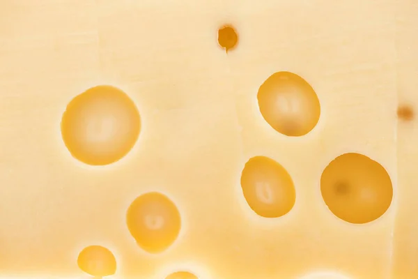 Close up view of textured yellow cheese with wholes — Stock Photo