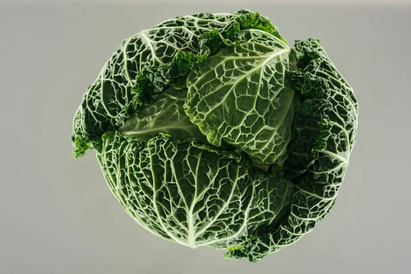 Вид зверху на зелену свіжу органічну цілу капусту з листям ізольовано на сірому — стокове фото