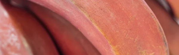 Coup panoramique de peau texturée de banane rouge exotique mûre — Photo de stock