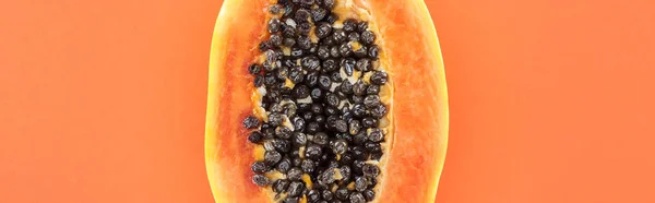 Panoramic shot of ripe exotic papaya half with black seeds isolated on orange with copy space — Stock Photo