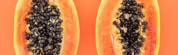 Plano panorámico de mitades de papaya con semillas negras aisladas en naranja - foto de stock