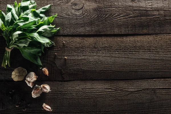 Vue de dessus du basilic vert, gousses d'ail et poivre noir sur table rustique en bois — Photo de stock
