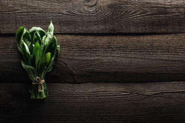 Vue de dessus des feuilles d'épinards verts sur la table rustique en bois — Photo de stock