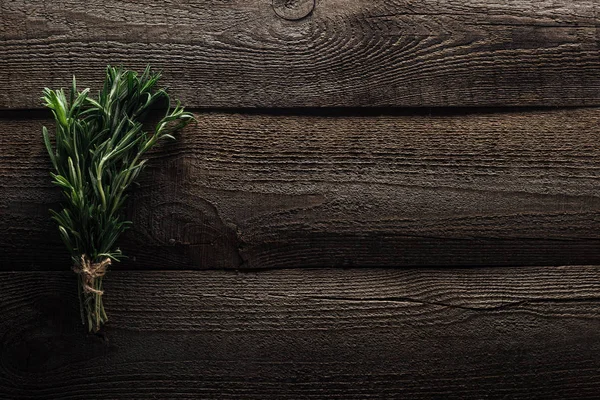 Top view of green rosemary on wooden weathered table with copy space — Stock Photo