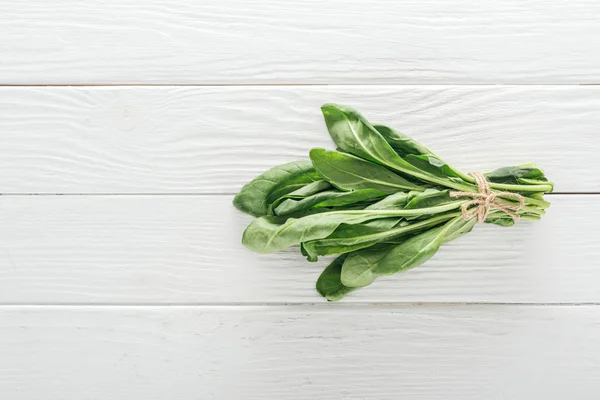 Vue de dessus des feuilles d'épinards verts sur la table en bois blanc — Photo de stock