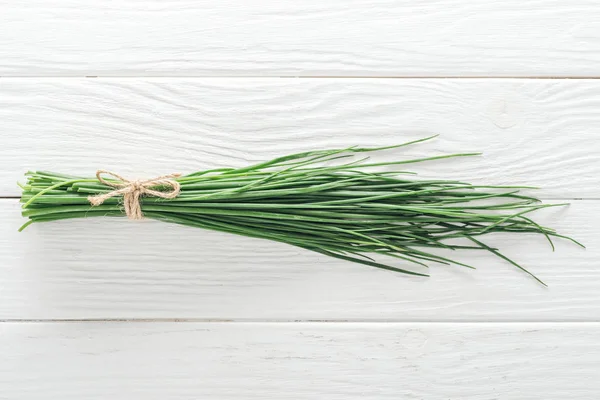 Draufsicht auf frische grüne Zwiebeln auf weißem Holztisch — Stockfoto