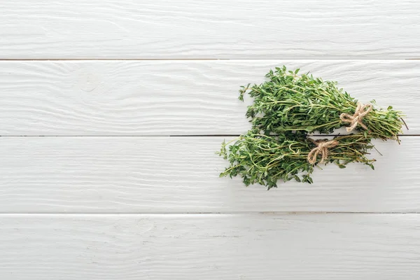 Vue du dessus du thym vert frais sur une table en bois blanc — Photo de stock