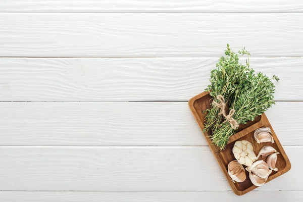 Vue de dessus de thym vert frais et gousses d'ail sur table en bois blanc — Photo de stock