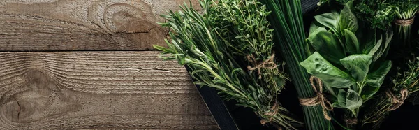 Plano panorámico de tomillo verde, espinacas, romero y cebolla verde en caja sobre mesa envejecida de madera con espacio para copiar - foto de stock