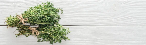Top view of fresh green thyme on white wooden table, panoramic shot — Stock Photo
