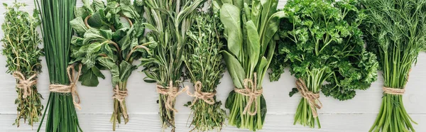 Top view of various green herbs on white wooden table, panoramic shot — Stock Photo