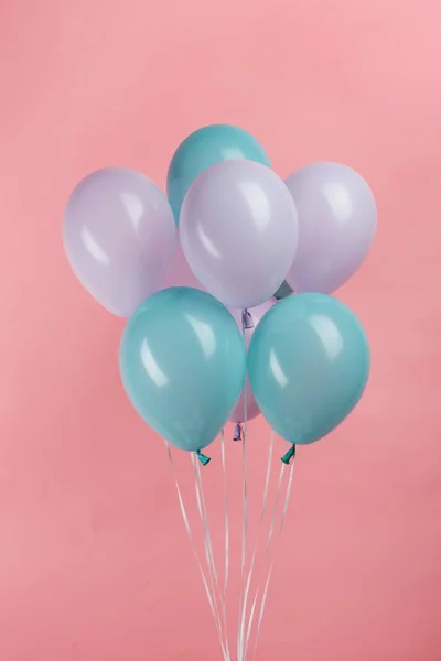 Ballons de fête bleus et violets sur fond rose — Photo de stock