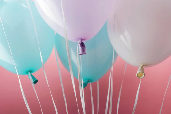 Nahaufnahme von blauen, weißen und lila Luftballons auf rosa Hintergrund — Stockfoto