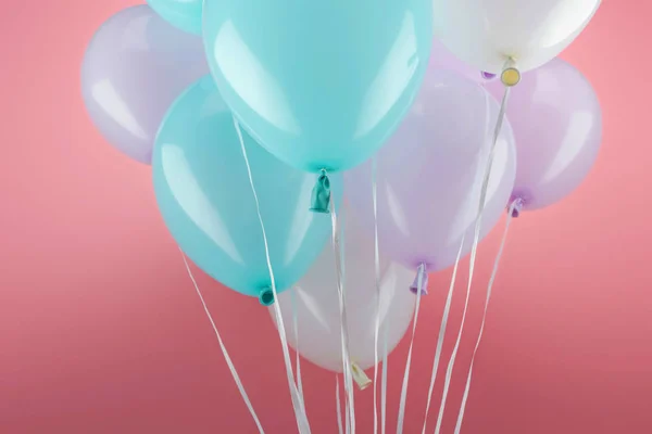 Balões decorativos azuis, brancos e roxos sobre fundo rosa — Fotografia de Stock