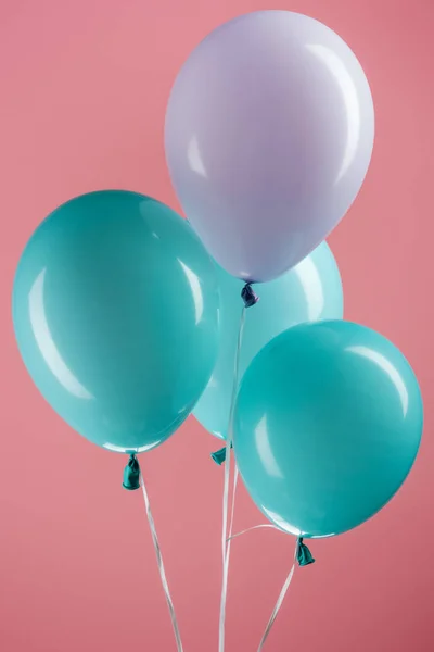 Ballons décoratifs colorés bleus et violets sur fond rose — Stock Photo