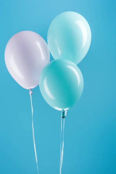 Globos festivos púrpura y azul sobre fondo azul - foto de stock