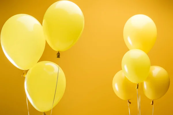 Ballons minimalistes lumineux festifs sur fond jaune — Photo de stock