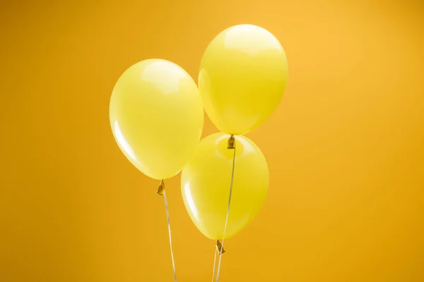 Globos decorativos coloridos festivos minimalistas sobre fondo amarillo - foto de stock