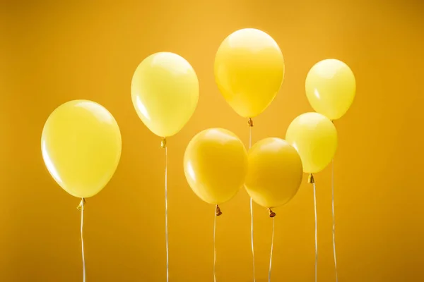 Balões minimalistas brilhantes festivos no fundo amarelo — Fotografia de Stock