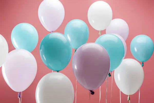 Luminosi palloncini decorativi multicolori su sfondo rosa — Foto stock