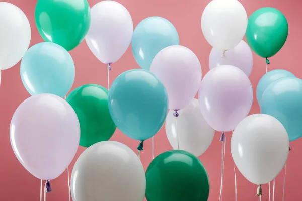 Balões decorativos verdes, brancos e azuis brilhantes sobre fundo rosa — Fotografia de Stock